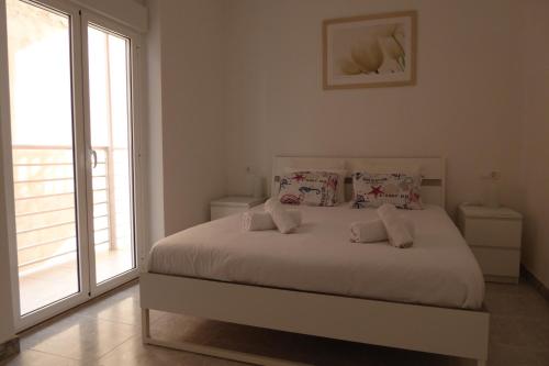 a bedroom with a white bed with two pillows at Sea View lo pagan in San Pedro del Pinatar