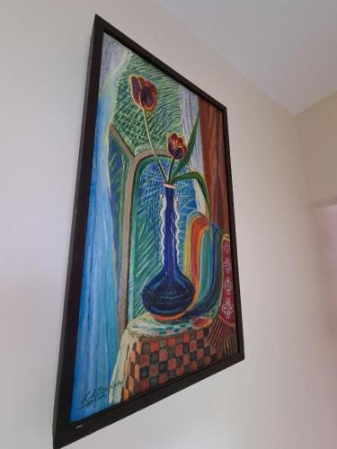 a painting of a blue vase with flowers in it at Apartament Bogdan in Gura Humorului