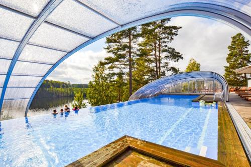 a large swimming pool with a bridge over a body of water at Årjäng Camping & Stugor Sommarvik in Årjäng
