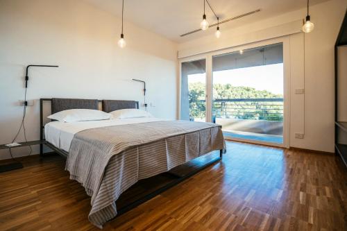a bedroom with a bed and a large window at SPORTING PINAMARE in Marina dʼAndora
