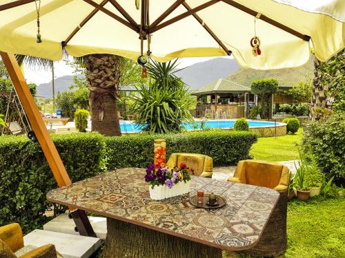 a table under an umbrella with flowers on it at Papirus Hotel in Adrasan