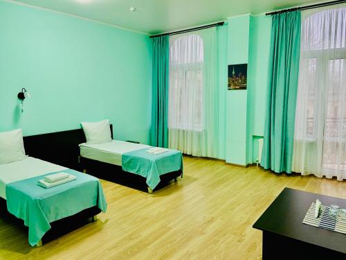 a blue room with two beds and a table at Гостевой дом Селена in Rostov on Don