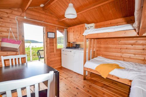 1 dormitorio con 1 cama y 1 mesa en una cabaña en Årjäng Camping & Stugor Sommarvik en Årjäng