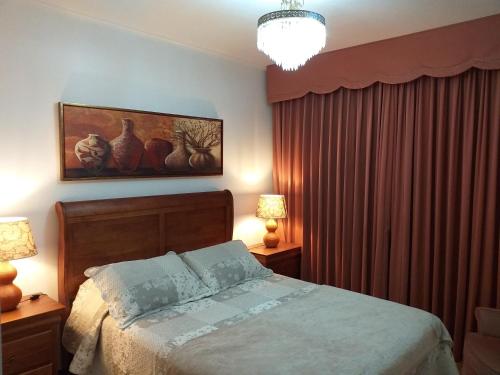 um quarto com uma cama e duas mesas com candeeiros em Terraza Santa Lucia,Suites "Como en su Casa" em Santiago