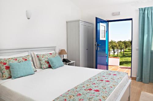 1 dormitorio con 1 cama blanca grande con almohadas azules en Outeiro do Barro en Reguengos de Monsaraz