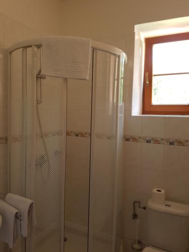 La salle de bains est pourvue d'une douche, de toilettes et d'une fenêtre. dans l'établissement Hotel Praha, à Deštné v Orlických horách