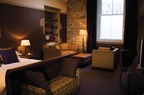 a hotel room with a bed and chairs and a window at Hotel Du Vin Edinburgh in Edinburgh