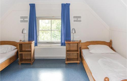 1 dormitorio con 2 camas y una ventana con cortinas azules en Beautiful Home In Den Ham With Wifi, en Den Ham