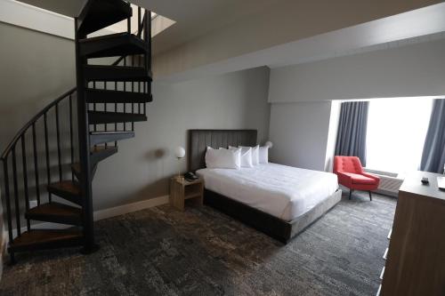 a hotel room with a bed and a spiral staircase at Lake Placid Inn Boutique Hotel in Lake Placid