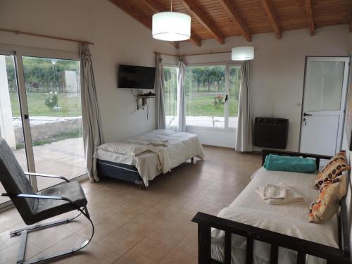 a living room with a bed and a couch and a tv at Cabañas Terruños de Pilar in Malargüe