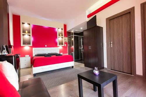 a red bedroom with a bed and a table at La Terra Nostra in Korinthos