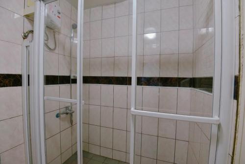 苗栗市的住宿－綠庭商務旅館，浴室铺有白色瓷砖,设有淋浴。