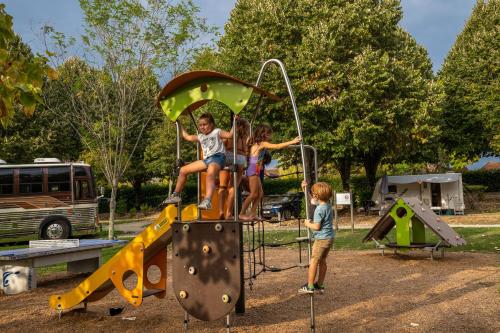 a group of children playing on a playground at Camping Beau Rivage in Navarrenx