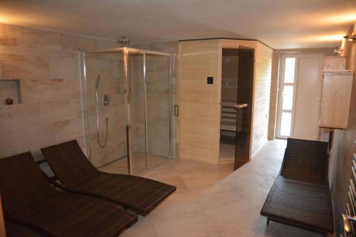 a bathroom with a shower and two chairs in it at Chata Nový svět in Strážné