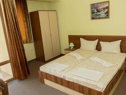a bedroom with a large bed with two towels on it at Villa Iztok in Sozopol