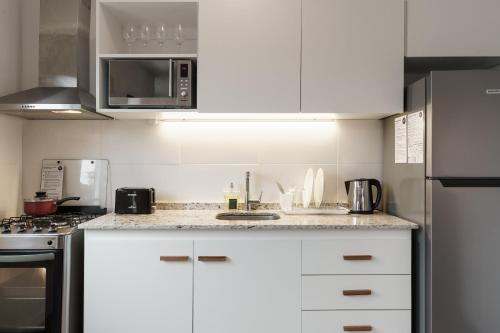 a kitchen with white cabinets and a counter top at Taurinas in Colonia del Sacramento