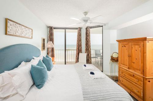 a bedroom with a bed and a large window at 214 COV - Go Fly a Kite - Oceanfront Condo - 2 Pools in Folly Beach