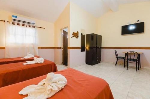 a hotel room with two beds and a television at Gran Turín Hotel Boutique parque,arte y tecnología in Villa Carlos Paz