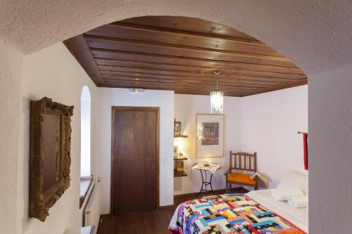 a bedroom with a bed with a wooden ceiling at Mpelleiko in Stemnitsa