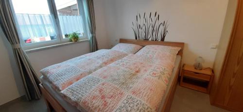 a bedroom with a bed with two pillows and a window at Ferienwohnung Weinbergblick in Naumburg