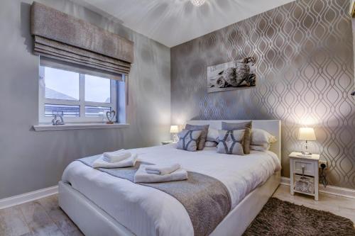 a bedroom with a large bed with towels on it at No 7 Ayr Beach - Coorie Doon in Ayr