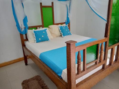 a bedroom with two bunk beds with blue pillows at saba saba home stay in Nungwi