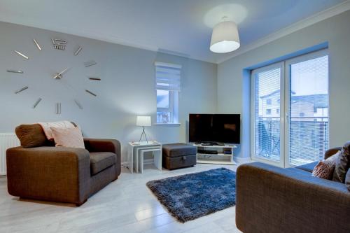 a living room with a large clock on the wall at No 7 Ayr Beach - Coorie Doon in Ayr