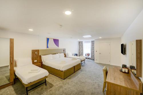 ein Hotelzimmer mit 2 Betten und einem TV in der Unterkunft OYO Plymouth Central Hotel in Plymouth