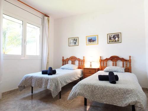 a bedroom with two beds and a window at Villa Nerea with air conditioning & private swimming pool only 400m to the beach ideal for families in L'Ametlla de Mar