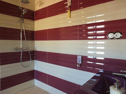 Baño con rayas rojas y blancas en la pared en Villa Tranquila a charming 4bedroom villa with air-conditioning & private swimming pool, en L'Ametlla de Mar
