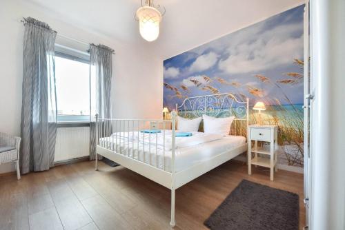 - une chambre avec un lit blanc et une peinture murale dans l'établissement Haus Thalia 3 - Seestern, à Ahlbeck