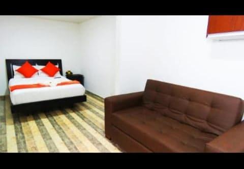 un soggiorno con divano e letto di Hotel Casa Román a Bogotá