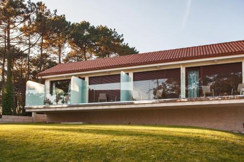 a house with a large balcony on top of a yard at Hotel Alén do Mar in Finisterre