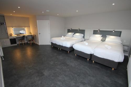 a hotel room with two beds and a desk at North Coast Motel in Portrush