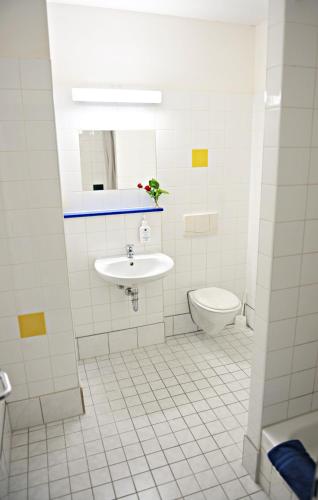 a white bathroom with a sink and a toilet at Hotel Transit Loft in Berlin