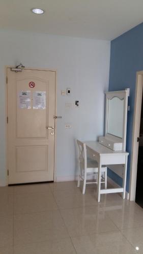 a room with a table and a door and a mirror at Baanchomchan in Hua Hin