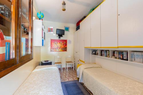 een slaapkamer met 2 bedden en een boekenplank bij Casa Amena in Minori