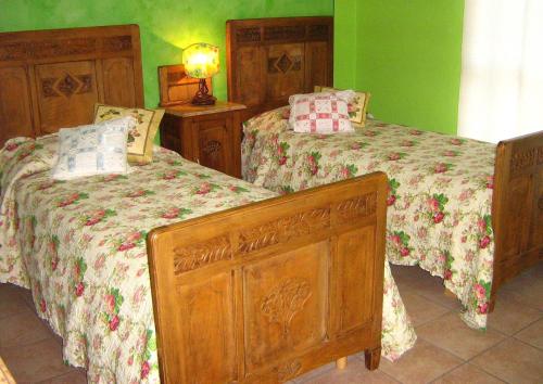 two beds in a bedroom with green walls at B&B Casa Dolce Casa in Candelo