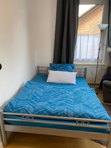 a blue bed in a room with a window at WG Zimmer 108 in Holzminden