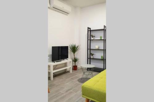 a living room with a green couch and a tv at Suite by Hawkins interior BA in Algeciras