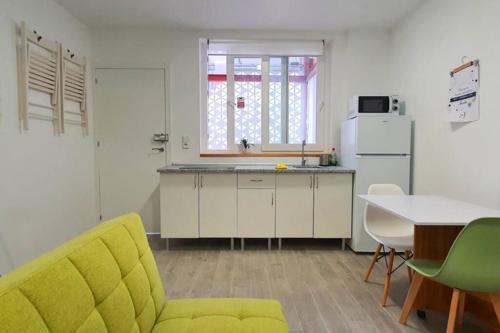 a kitchen with a yellow couch and a table at Apartamento interior en el absoluto centro BA in Algeciras