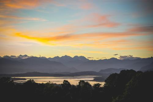 a view of a lake and mountains at sunset at Villa Cagnola in Varese