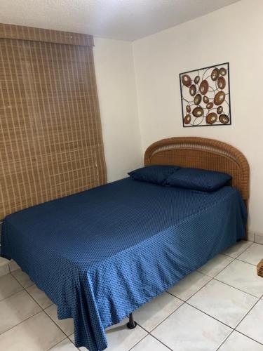a bedroom with a bed with a blue bedspread at Caguax 206 in Cabo Rojo