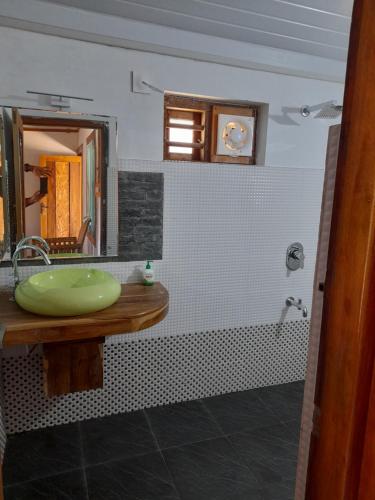 a bathroom with a green sink and a mirror at Riverlap homestay in Nīleshwar