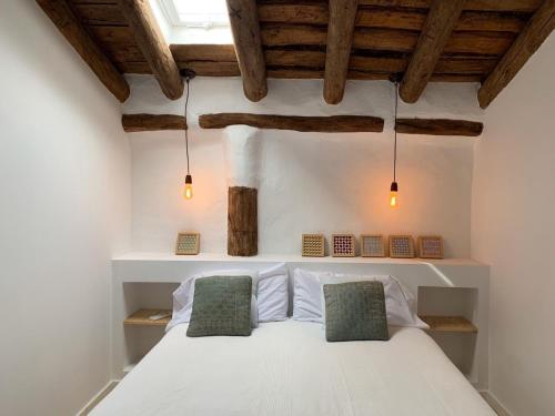 1 dormitorio con 1 cama blanca y 2 almohadas verdes en Astarte House 6 pax up en Galera