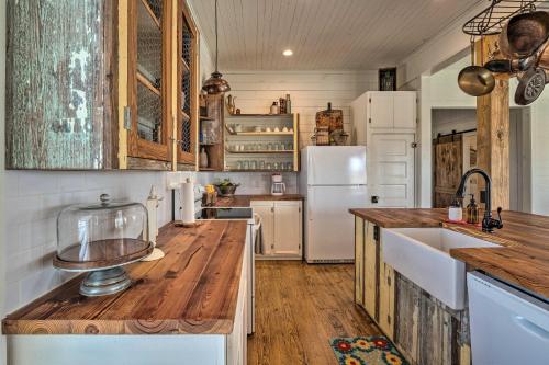 a kitchen with wooden floors and a white refrigerator at Pool, Hot Tub and Game Room Schulenburg Retreat in Schulenburg