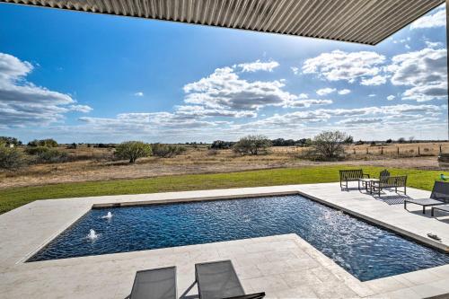 a swimming pool in the middle of a yard with chairs at Pool, Hot Tub and Game Room Schulenburg Retreat in Schulenburg