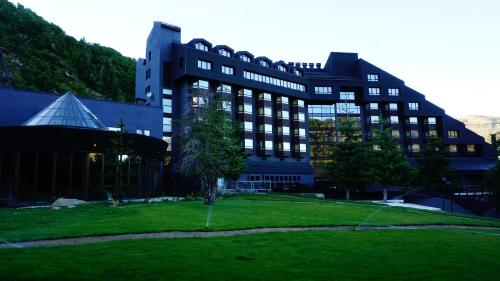 a large building with a green lawn in front of it at Hotel Termas Chillán in Nevados de Chillan