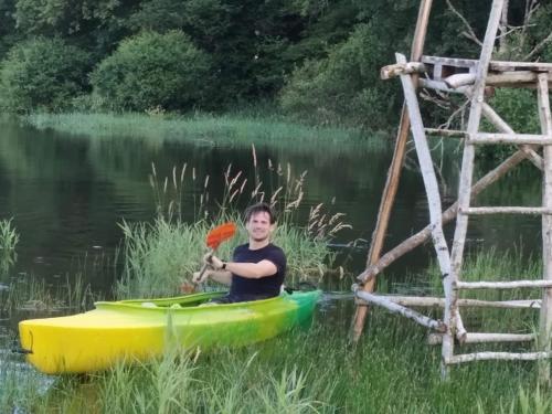 a man sitting in a kayak next to a wooden ladder at La Tribu de Lavaud in Saint-Quentin-sur-Charente