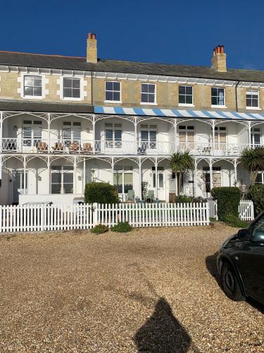 a large white house with a white fence and a car at Ventnor Bay House in Ventnor